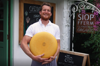 WILDFundraiser business - organic farm owner holding wheel of cheese