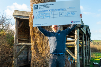 John holding a jumbo cheque