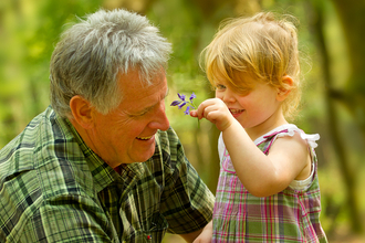 Picture of a child showing her grandfather a bluebell