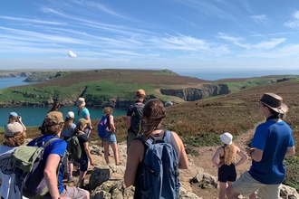 A group of birdwatchers on a guided tour of Skomer. The Neck is in the background.