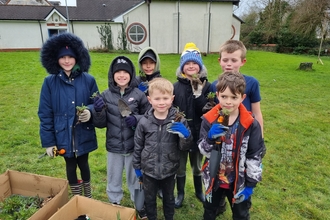 Group of children holding plant plugs.