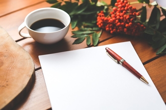 Paper and pen with a cup of tea
