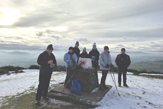 Brecon Local Group members by a trig point in snow