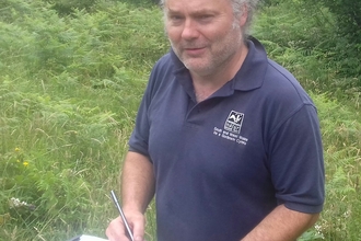 Doug with a clipboard outside.