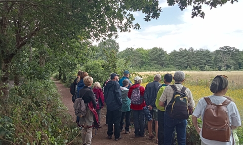 A group of people at our Welsh language walking group heading along a trail at Forest Farm.
