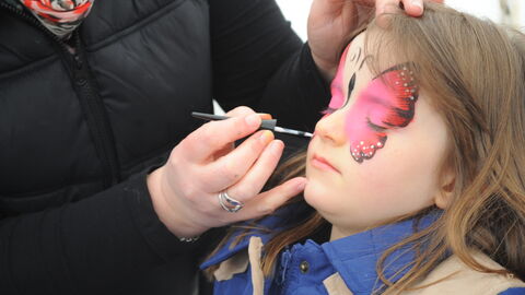 Butterfly being painted on child's face