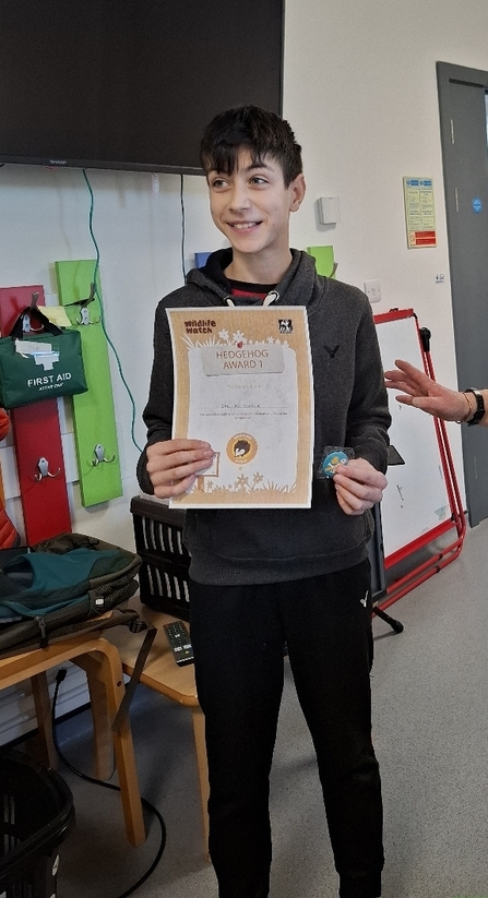 A boy receiving a Hedgehog Award certificate.  