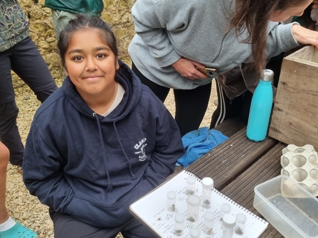 B2N youth member smiling after completing her moth match up quiz at an early morning light trap