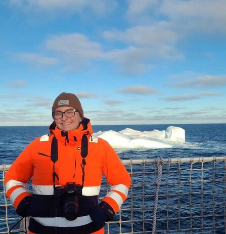 Maddy in front of an iceberg in Antarctica.