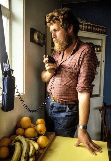 Mike Alexander holding radio in kitchen. 
