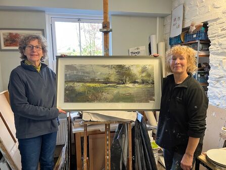 Artist Maggie Brown with landscape painting 