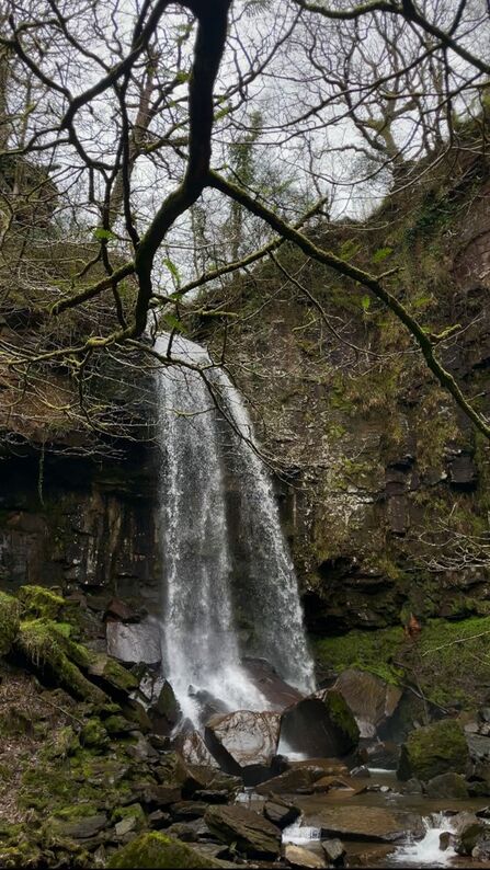 A large waterfall flowing in a dramatic landscape.