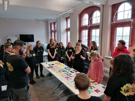 A group of people stood around a large table.