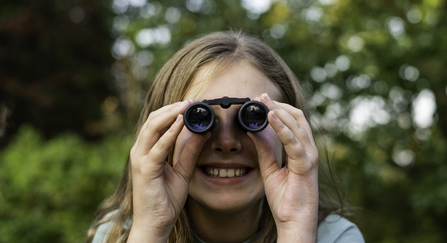 Young girl looking through binoculars