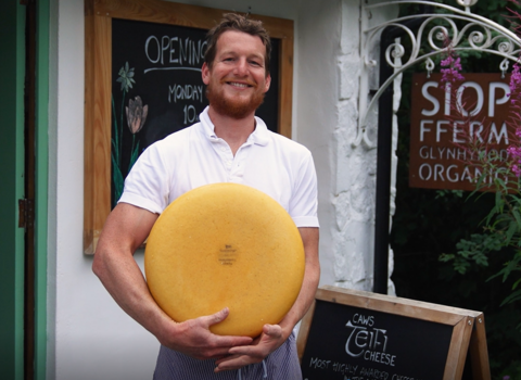 WILDFundraiser business - organic farm owner holding wheel of cheese