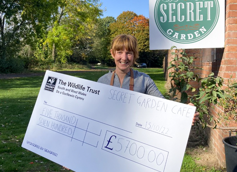 Mel from Secret Garden Cafe with fundraising cheque